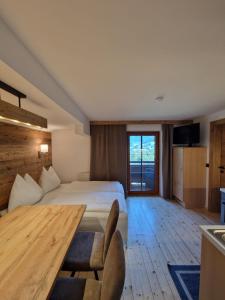 een hotelkamer met een bed en een houten tafel bij Teufenbachgut in Lend