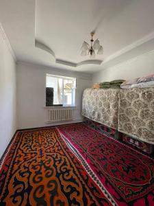 een slaapkamer met een bed en een groot tapijt bij Eco house in Naryn
