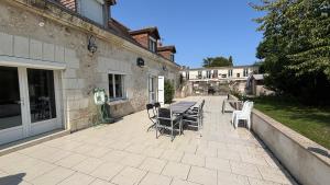 a patio with chairs and a table and a building at Maison familiale à la campagne in Vallères