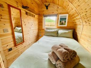 a bedroom with a bed in a wooden cabin at Crofters Coorie in Broadford