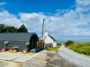 a barn with a windmill on the side of a road at Crofters Coorie in Broadford