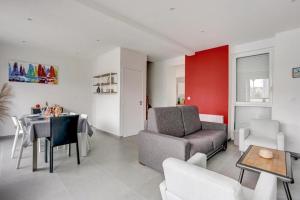 una sala de estar con un sofá y una mesa en L Abri Côtier, en Saint-Cast-le-Guildo