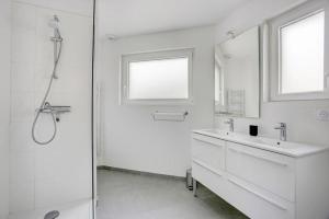 Un baño blanco con ducha y lavabo. en L Abri Côtier, en Saint-Cast-le-Guildo 5 fotos más