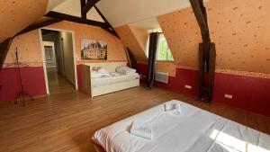 a large room with a bed in a attic at Maison familiale à la campagne in Vallères