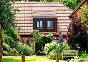 a house with a bench in front of a yard at Richtenberger Ente Apartments Ferienwohnungen in Richtenberg
