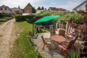 a table and chairs under an umbrella in a yard at Richtenberger Ente Apartments Ferienwohnungen in Richtenberg +102 photos