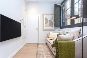 a living room with a couch and a flat screen tv at Genteel Home San Matías in Granada