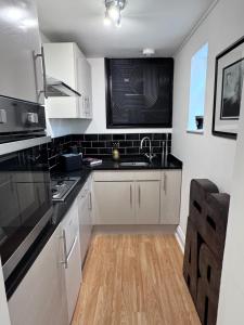 a kitchen with white cabinets and a sink at Regency Haven in London