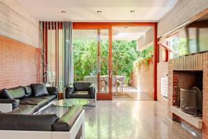 a living room with a couch and a fireplace at Villa with pool 150m from the sea in Punta Ala in Punta Ala