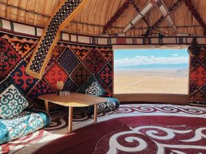 a room with a table and a view of the desert at Yurtada Charyn in Kökpek