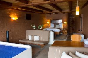 um quarto com 2 camas, um sofá e uma mesa em El Santuario Resort & Spa em Valle de Bravo