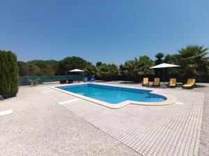 a swimming pool with chairs and umbrellas in a resort at Catshouse in Carqueja