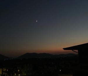 a moon in the sky over a city at sunset at Casa Xenia in Montesarchio +2 photos