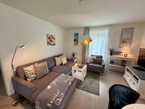 a living room with a couch and a chair at Aquamarin Ostseetraumsuite 05 in Neuhaus
