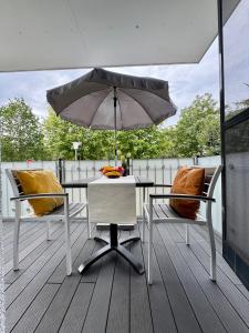 a table and two chairs and an umbrella on a deck at Aquamarin Ostseetraumsuite 05 in Neuhaus