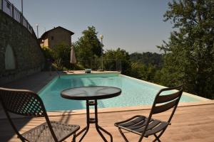 a table and chairs next to a swimming pool at tra Arte e Querce in Monchiero