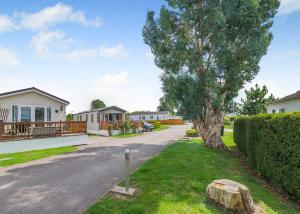 una casa con un árbol a un lado de la carretera en Cawood Country Park, en Cawood