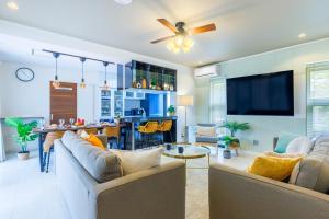 a living room with two couches and a table at 最大16名 BBQ可能 駐車場3台 シアタールーム付きのグループ旅行におすすめ宿 The MELIA in Yomitan