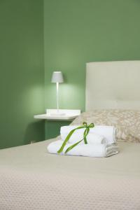 a bedroom with a white bed with a flower on it at Residenza IL COLLE in Subiaco