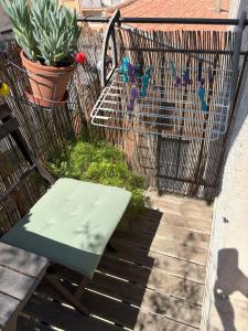 a green bench sitting on a patio with a chicken coup at Le Jean Moulin Vert in Sète