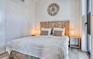a bedroom with a large white bed with two lamps at Awesome Home In Kerkdriel With Wifi in Kerkdriel
