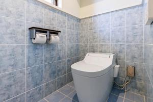 a bathroom with a toilet and two rolls of toilet paper at 最大16名 BBQ可能 駐車場3台 シアタールーム付きのグループ旅行におすすめ宿 The MELIA in Yomitan +79 photos