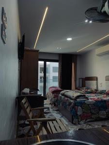 a hotel room with two beds and a chair and a window at Studio in Porto Said Compound in Port Said