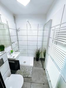 a white bathroom with a toilet and a sink at FeWo Markert in Burgtiefe auf Fehmarn 