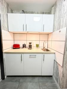 a kitchen with white cabinets and a sink at FeWo Markert in Burgtiefe auf Fehmarn 