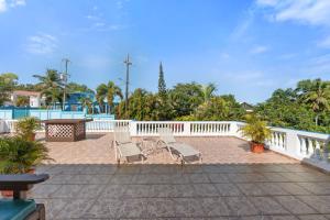 a patio with two lounge chairs and a fence at Vista del Mar terrace with pool table and views in Rincon
