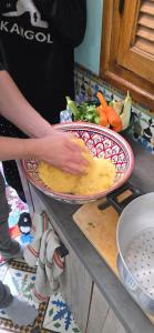 una persona que prepara comida en dos platos sobre un mostrador en atelier de cuisine, en Marrakech