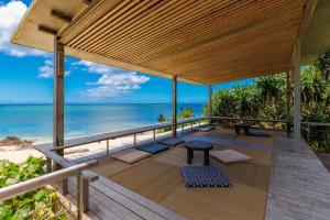 an outdoor deck with a view of the ocean at 最大16名 BBQ可能 駐車場3台 シアタールーム付きのグループ旅行におすすめ宿 The MELIA in Yomitan