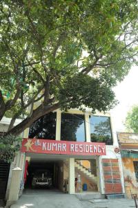 ポンディシェリにあるLe Kumar Residencyの木の下にキマー修復の看板がある建物 +11枚の写真