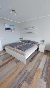 a bedroom with a large bed and a wooden floor at Ferienwohnung "Seestern" in Burgtiefe auf Fehmarn 