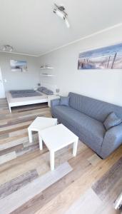 a living room with a blue couch and a table at Ferienwohnung "Seestern" in Burgtiefe auf Fehmarn 