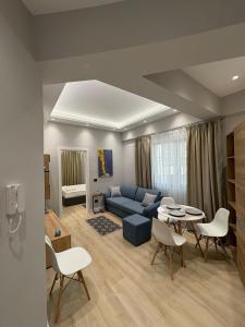 un salon avec un canapé, une table et des chaises dans l'établissement glenz apartments, à Vlorë
