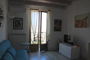 a living room with a blue couch and a window at Casa Don Raffaele in Agira