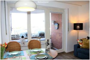 a living room with a table and chairs and a window at Hafenblick Orth in Orth