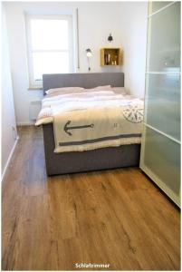 a bedroom with a bed and a wooden floor at Hafenblick Orth in Orth