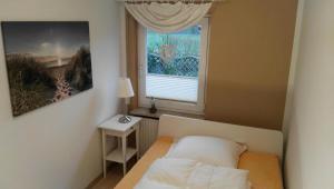 a small bedroom with a bed and a window at Hus Kalli in Landkirchen