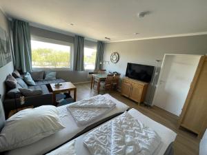 a bedroom with a bed and a living room at Kaleu in Burgtiefe auf Fehmarn 