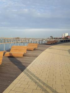 a row of benches on a boardwalk near the water at Kaleu in Burgtiefe auf Fehmarn  +7 photos