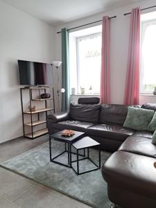 a living room with a leather couch and a table at Janita in Meeschendorf