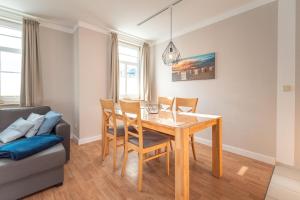 a dining room with a table and chairs and a couch at Haus am Kurpark - Whg 1 in Ahlbeck