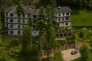 a large house with a car parked in front of it at Vilãsa Lall Ji Resort in Dalhousie