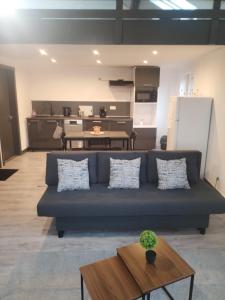 a living room with a blue couch and a table at Duplexe cosy Gosselies proche aéroport in Charleroi