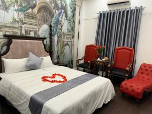 a bedroom with a bed with two red chairs at Khách sạn Đặng Anh in Hanoi