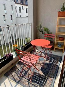a red table and two chairs on a balcony at Spacious & cosy apartment center in Ghent