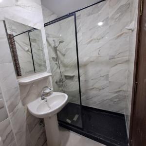 a white bathroom with a shower and a sink at Tiba Golden Beach Resort, Down Town in Hurghada