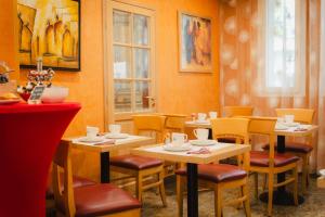 a restaurant with tables and chairs in a room at Grand Hotel Dore in Paris